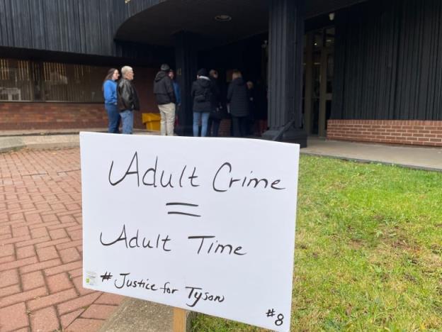 A sign reading adult crime = adult time and Justice for Tyson on a lawn outside a courthouse.