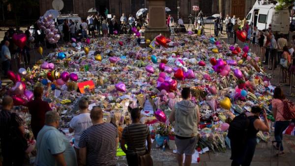 People stand next to flowers for the victims of the attack in 2017. Pic: AP