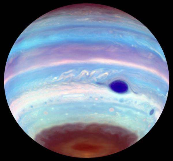 Magnetic tornadoes: Jupiter in blue and purple hues with a dark blue spot and brownish red patch at the south pole.