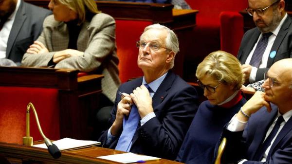 French Prime Minister Michel Barnier adjusts his tie as he attends a debate on two motions of no-co<em></em>nfidence against the French government.
Pic: Reuters