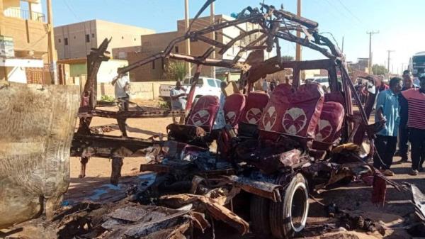 People gather near a destroyed vehicle, following shelling by the Rapid Support Forces, in Omdurman, Sudan, December 10, 2024