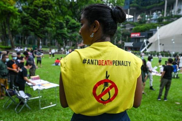 An activist wears a T-shirt with a sign against the death penalty during a protest against the death penalty at Speakers' Corner in Singapore on April 3, 2022. (Photo by Roslan RAHMAN / AFP)