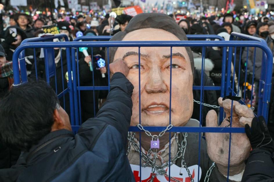 A protester punches an effigy of South Korea President Yoon Suk Yeol. 