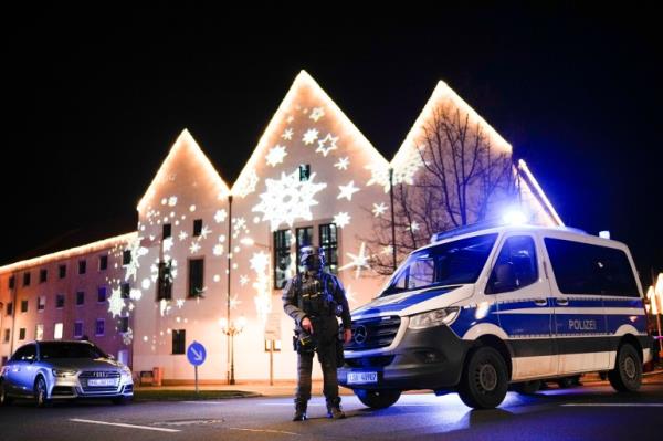 A police vehicle and officer near a Christmas market after a suspected attack in Magdeburg