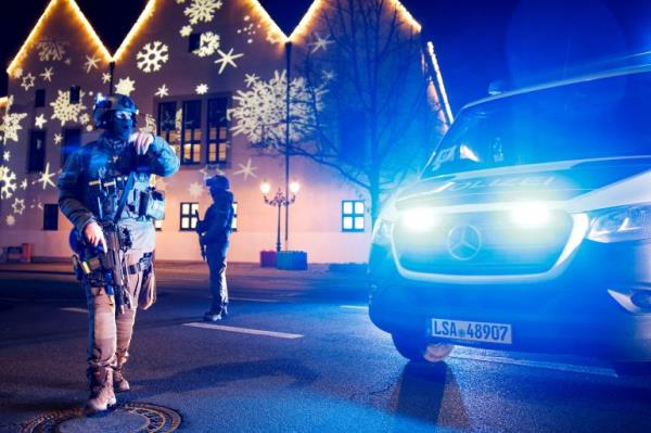 A police officer stands in front of decorations for a German Christmas market involved in an apparent attack.