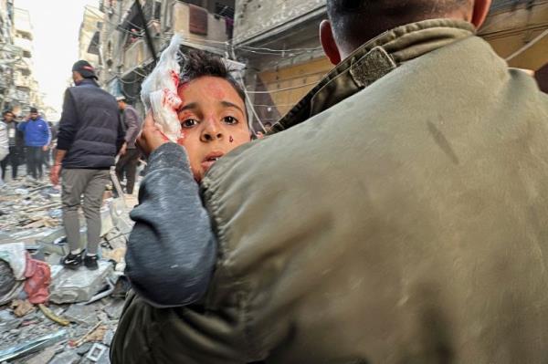 Palestinian carries a wounded child at the site of an Israeli strike on an apartment, amid the o<em></em>ngoing co<em></em>nflict between Israel and Hamas, in Nuseirat, central Gaza Strip.