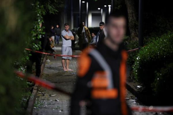 People gather at the scene of a missile strike that, according to Israel’s military, was launched from Yemen and landed in Jaffa.