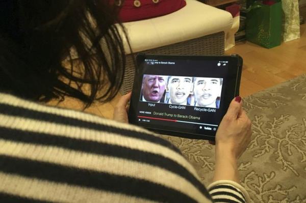 A woman in Washington, DC, views a manipulated video on January 24, 2019, that changes what is said by Do<em></em>nald Trump and former president Barack Obama, illustrating how deepfake technology can deceive viewers. (Rob Lever/AFP)