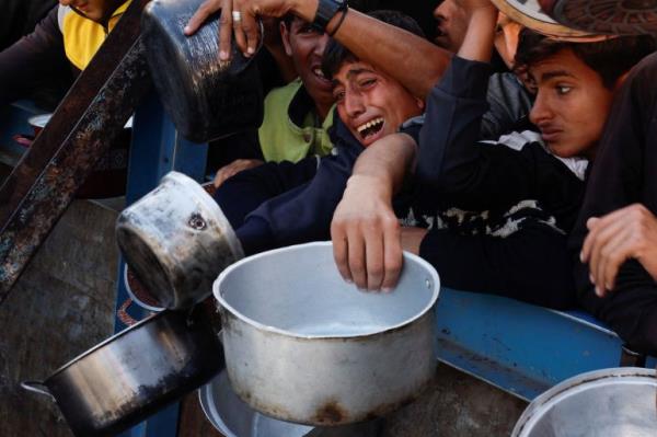 Palestinian children gather to receive food in Gaza amid Israel's war