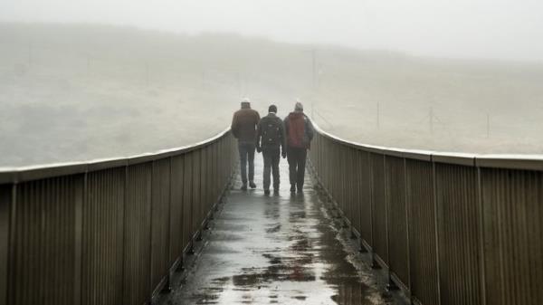 People walk over a foot bridge in foggy co<em></em>nditions near Saddleworth Moor on Saturday. Pic: PA