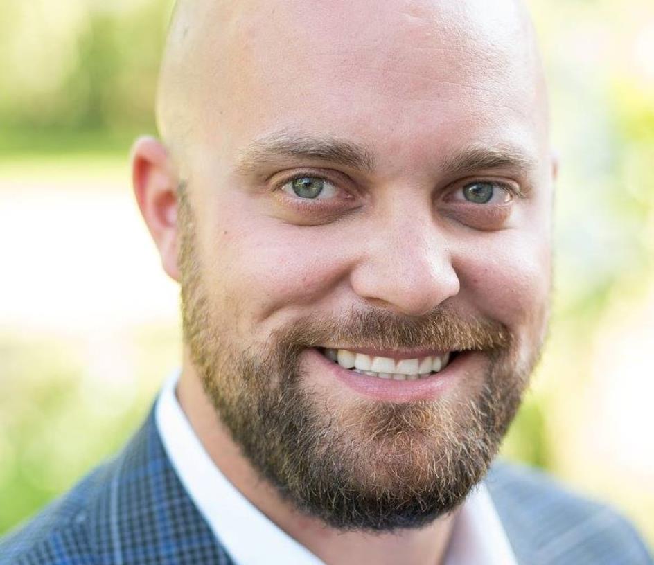 headshot of man in suit smiling