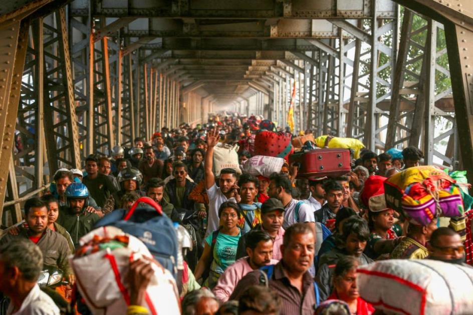 A large crowd walks along a large covered bridge.