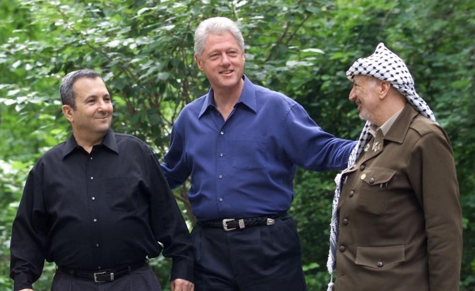 Israeli Prime Minister Ehud Barak (L), US President Bill Clinton (C), and Palestinian leader Yasser Arafat pause for a photo as they tour Laurel Cabin, the site wher<em></em>e former Egyptian President Anwar Sadat, former Israeli Prime Minister Menachem Begin, and US President Jimmy Carter co<em></em>nducted peace talks in 1978, during the Middle East Peace Summit 11 July 2000 at Camp David, Maryland, the US presidential mountain top retreat. The peace talks are aimed at resolving the issues of the 52-year-old Israeli-Palestinian co<em></em>nflict including the status of Jerusalem, the borders and nature of a Palestinian state, and the future of Jewish settlers and Palestinian refugees.   