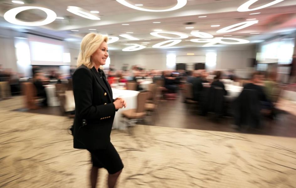 Bo<em></em>nnie Crombie walking through a room with blurred background. 