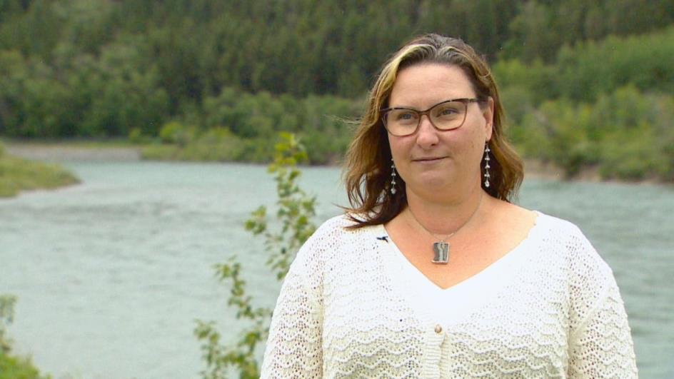 A woman is pictured in front of a river.