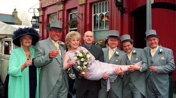 EastEnders stars Barbara Windsor (Peggy Mitchell) and Mike Reid (Frank Butcher second left), with co-stars outside the Queen Vic pub for their wedding. Pic: PA