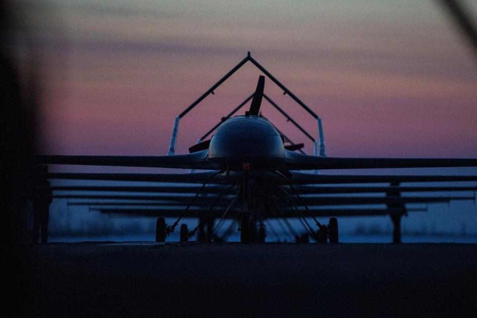 A plane is shown on a landing trip in a semi-darkened sky, either during sunrise or sunset