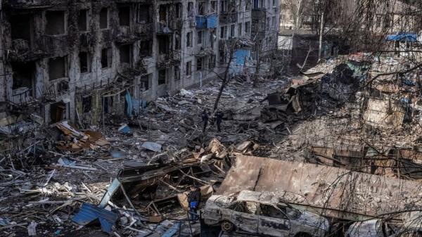 People stand at the site of an apartment building hit by a Russian missile strike in Dobropillia. Pic: Reuters