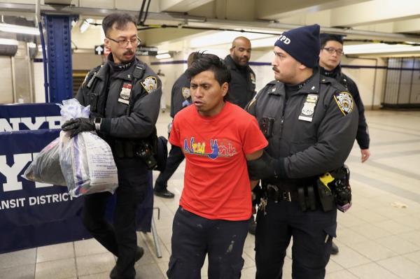 NYPD officers escort a suspect wanted for a homicide on the subway in Co<em></em>ney Island out of TD2 in lower Manhattan Sunday, Dec. 22, 2024.