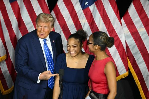 Former US President Do<em></em>nald Trump speaking a<em></em>bout school choice with students Makayla and Leah Lawrence at a campaign event at Discovery World in Milwaukee, Wisconsin