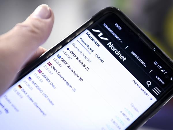 A person examining stock market indices on a smartphone in Helsinki in November 2020.