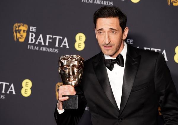 Adrien Brody holds up trophy after earning the Best Actor in a Leading Role award for 