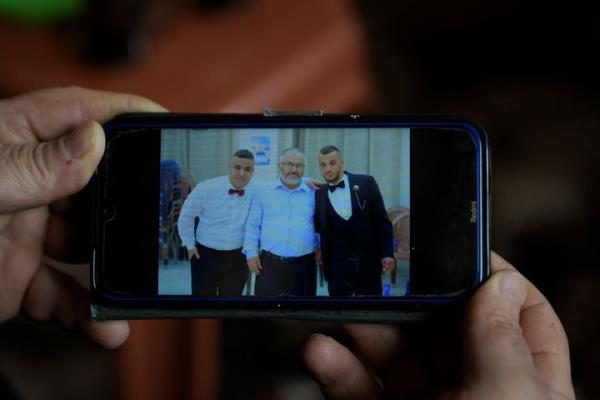 Mohammed Shula shows a picture on his phone of him and his sons, Bilal and Yazan, inside a relative's house wher<em></em>e he and his wife have taken refuge in the West Bank village of Kafr al-Labad, on Monday, Feb. 10, 2025.