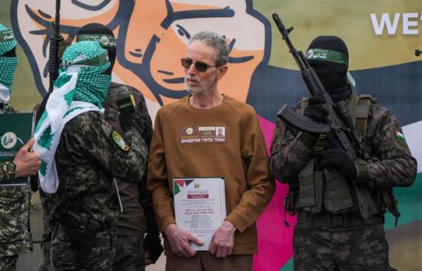 Ohad Ben Ami, an Israeli who has been held hostage by Hamas in Gaza since Oct. 7, 2023, is escorted by fighters before getting handed over to the Red Cross in Deir al-Balah, central Gaza Strip, on Saturday Feb. 8, 2025.