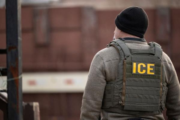 An Immigration and Customs Enforcement (ICE) agent stands on a street during a multi-agency targeted enforcement operation in Chicago on Jan. 26, 2025. 