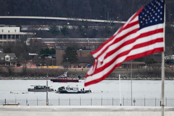 A police boat gathers wreckage along the Potomac River after American Airlines flight 5342 on approach to Reagan Natio<em></em>nal Airport crashed into the river after colliding with a US Army helicopter, near Washington, DC, on January 30, 2025. (Photo by OLIVER CONTRERAS/AFP via Getty Images)